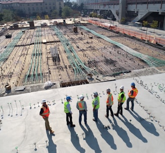 seven construction workers standing on white field