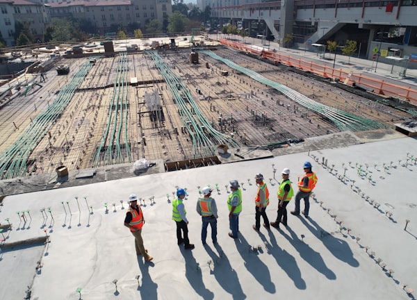 seven construction workers standing on white field