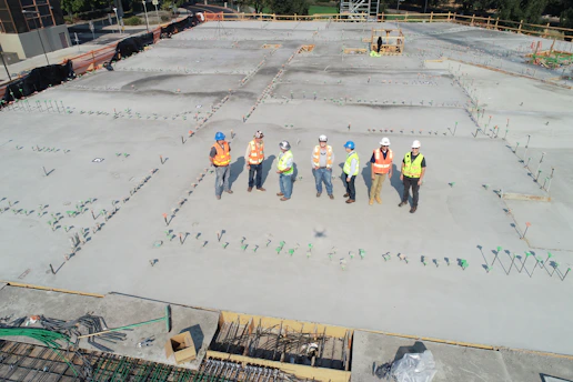 Consultant discussing safety protocols with construction workers outdoors.