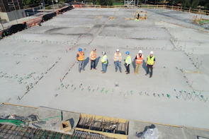 Group of OSHA-certified employees reviewing safety protocols on site with clear signage in the background.