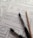 Several sheets of paper feature sketch-style website wireframes drawn with black marker lines. Two black markers and a wooden pencil rest on top of the papers, giving the scene a creative and informal touch.