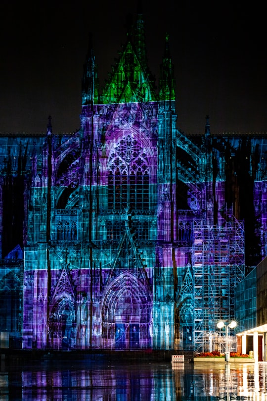 lighted church surrounded by body of water in Cologne Germany