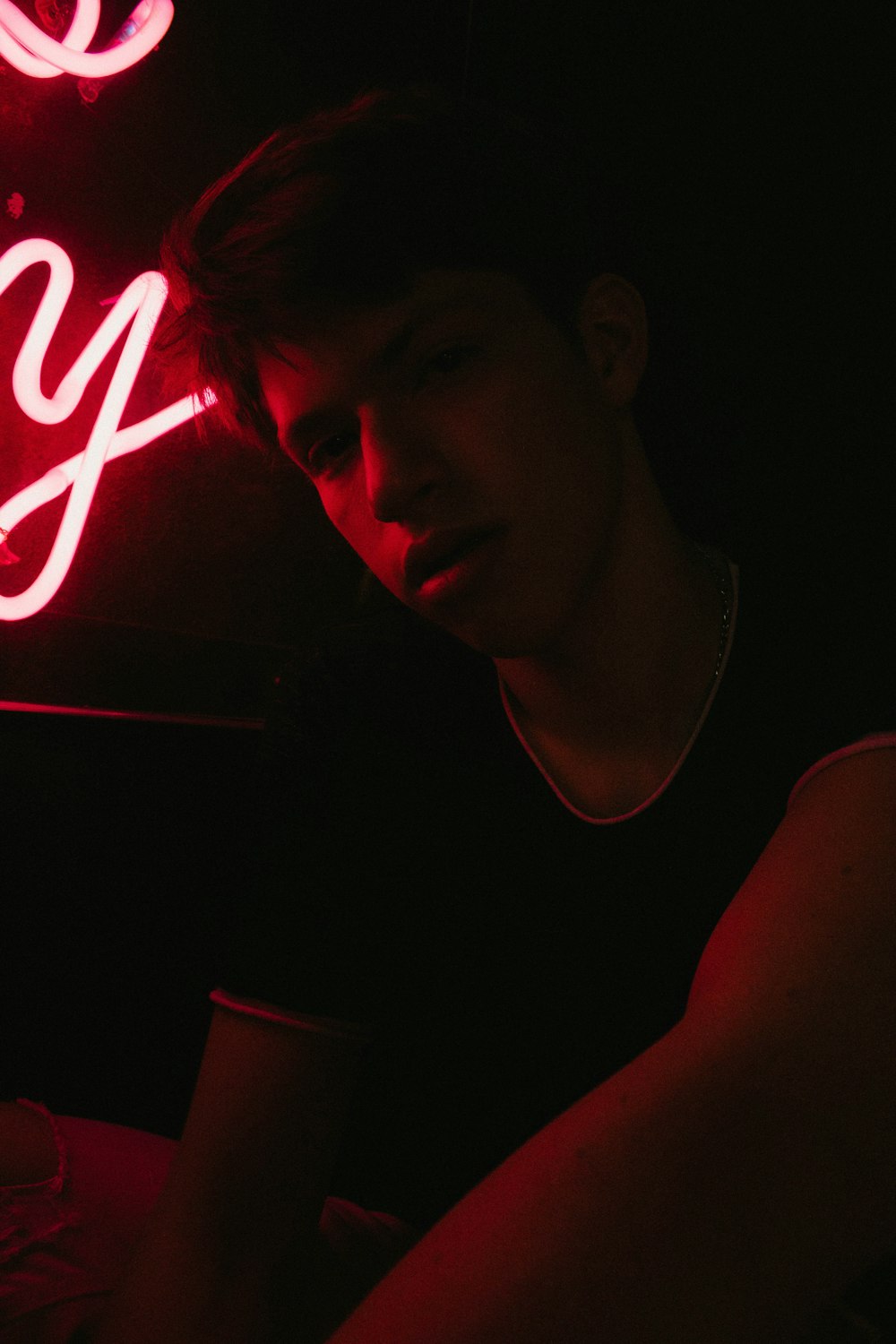 man beside red neon signage