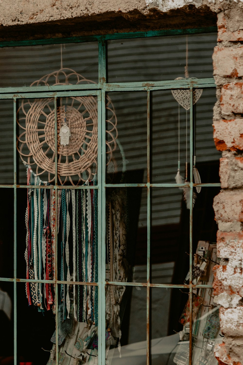 brown and teal dreamcatcher beside window