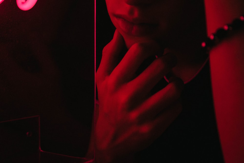 a woman standing in front of a mirror in a dark room