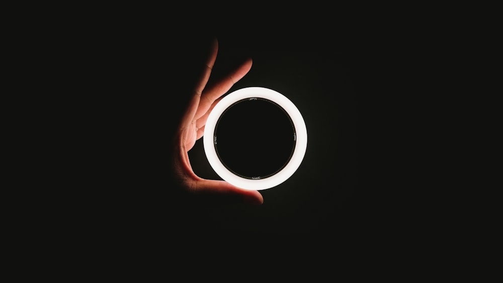 Persona sosteniendo un anillo de luz blanco