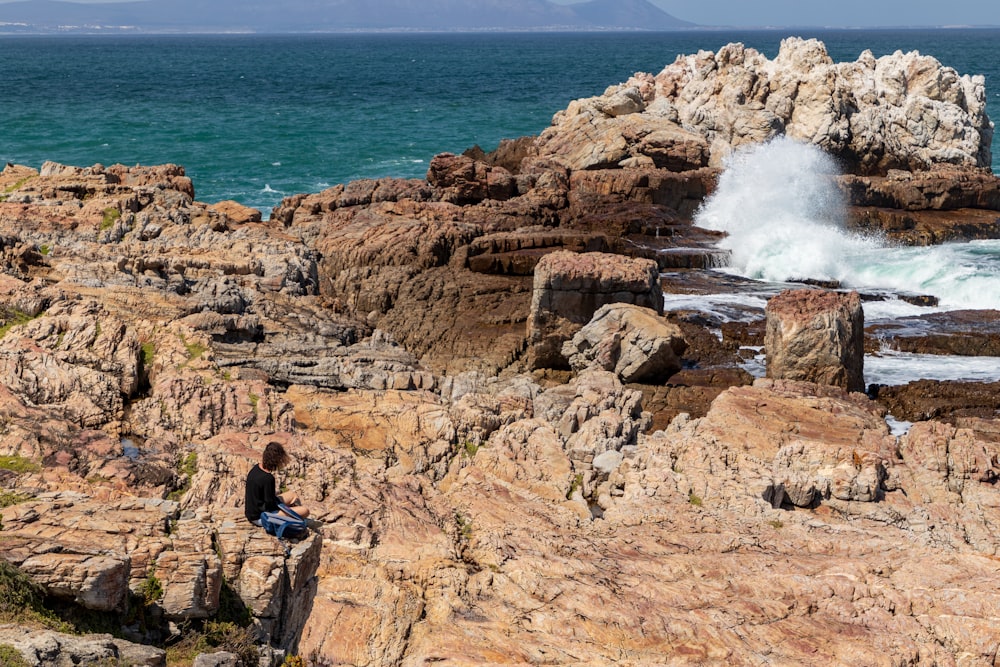 person sitting on rock