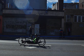 Para triathlete cycling with adaptive equipment on a sunny day.