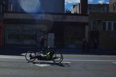 Para triathlete cycling with adaptive equipment on a sunny day.