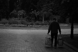 Casual outdoor shot of a woman walking with a laptop bag in a city park