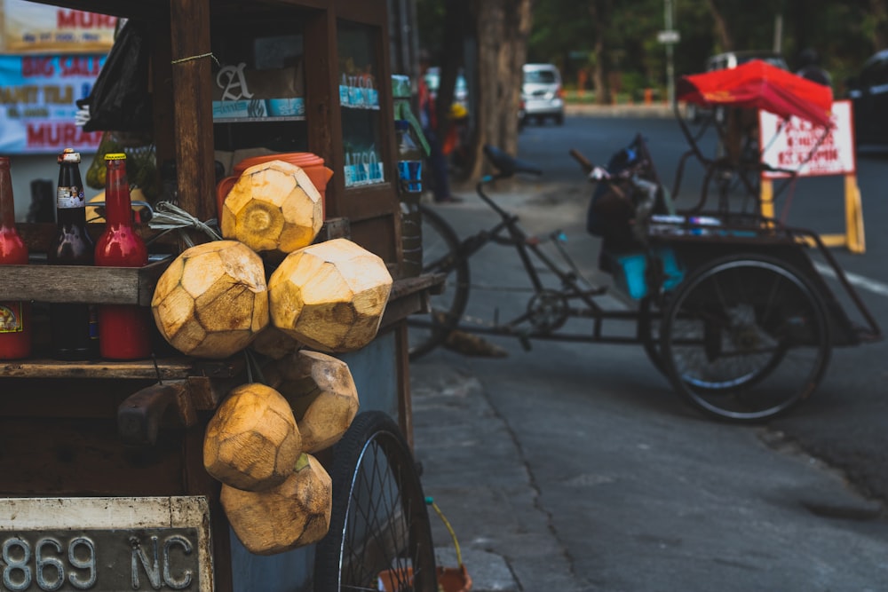 Seis cocoteros marrones colgados en el costado de un carro de madera
