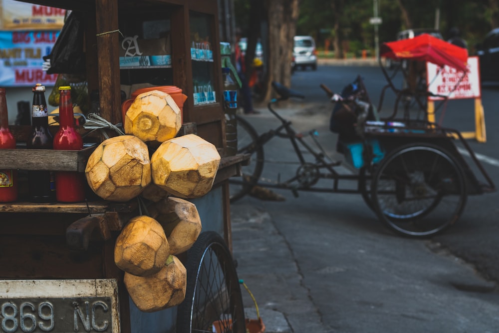 six brown coconut fruits hanged on side of wooden cart