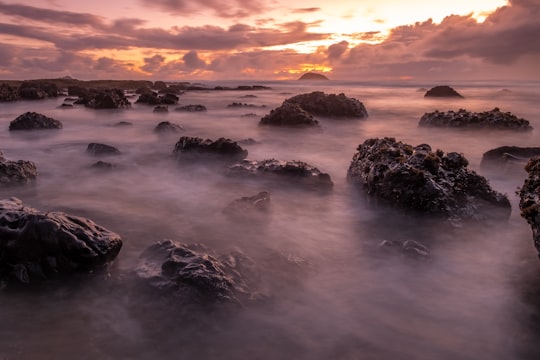 top view of mountains surrounded by clouds in Muriwai New Zealand