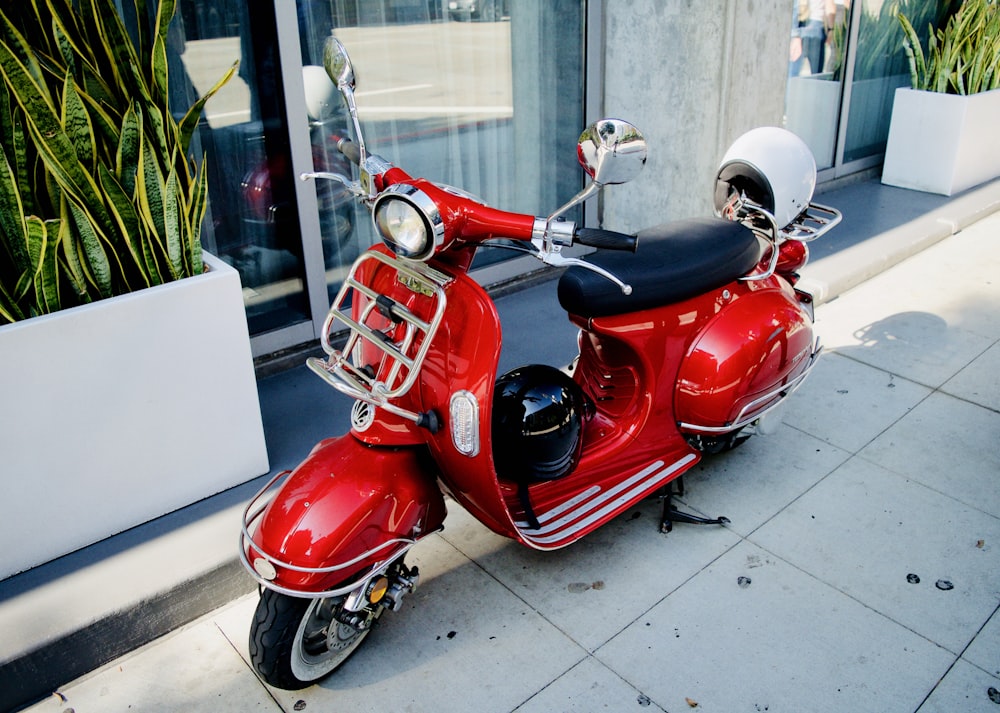 red motor scooter parked near glass door