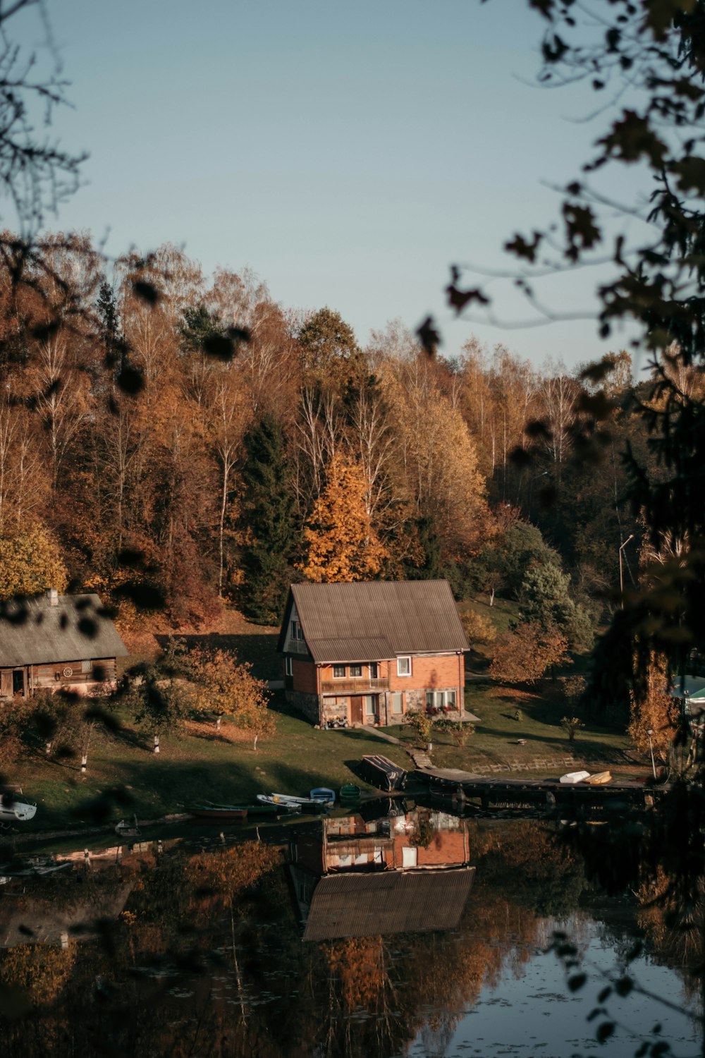 brown house near body of water and trees