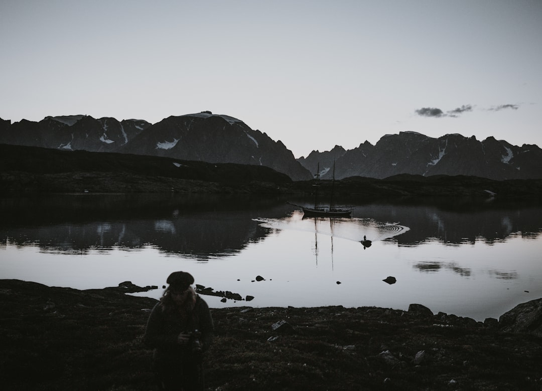 grayscale photography of woman near body of water