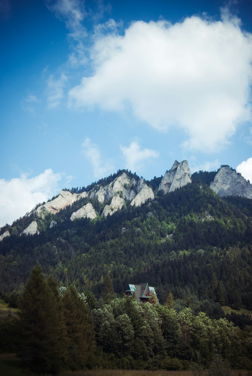 green mountain under blue and white sky