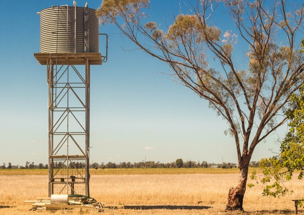water tank tower placed on barren ground during daytime