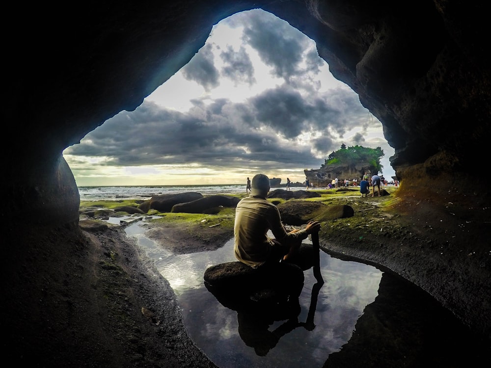 man sitting on stone during daytime