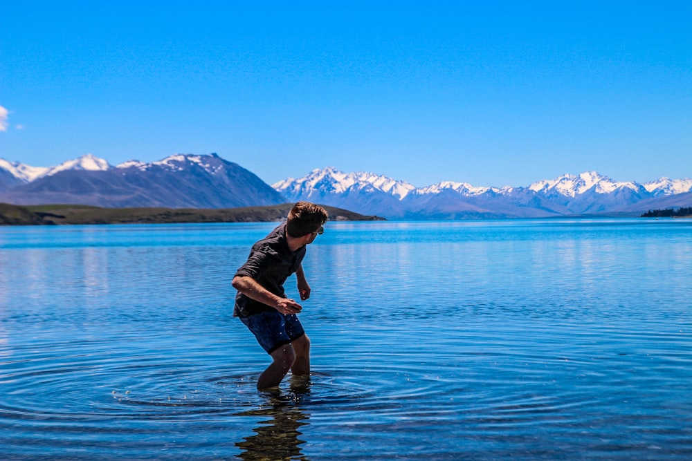 man throwing pebble on ocean water