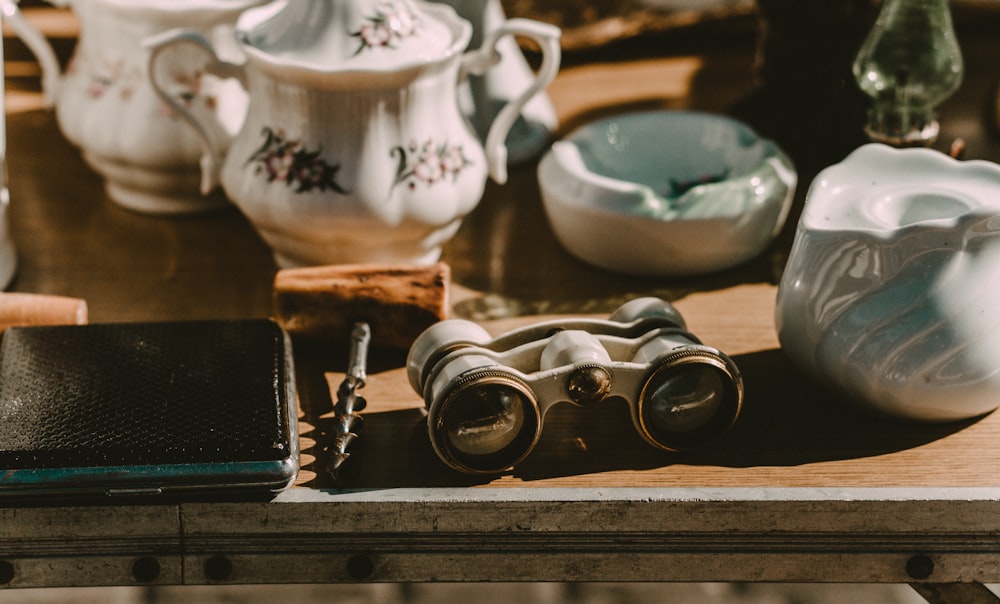 gray binocular beside white ceramic oil diffuser