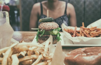person sitting at table with burger on it