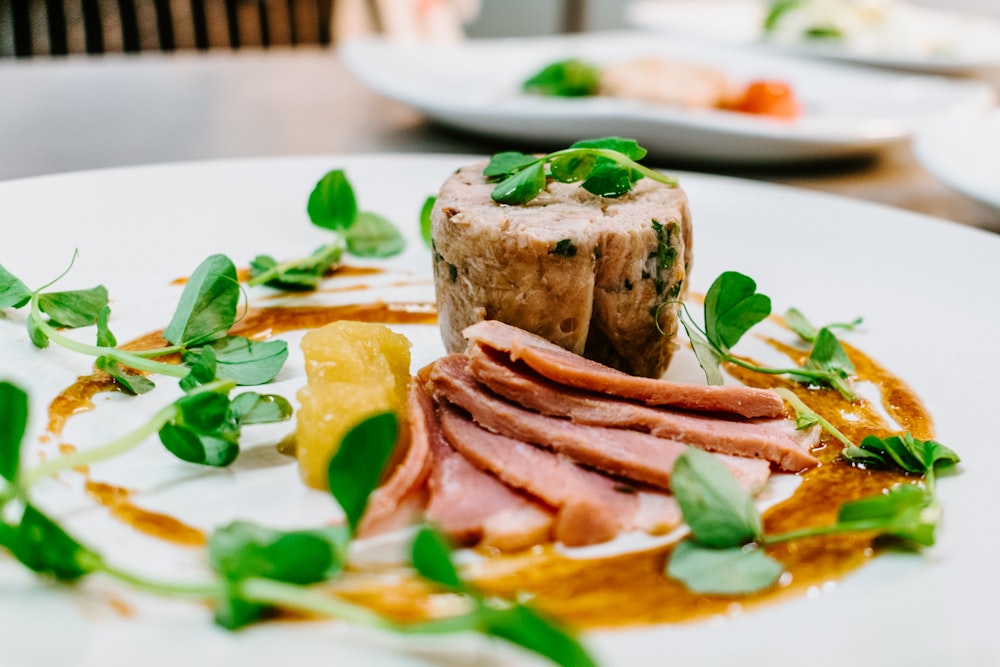 selective focus photography of cooked meat on round white plate