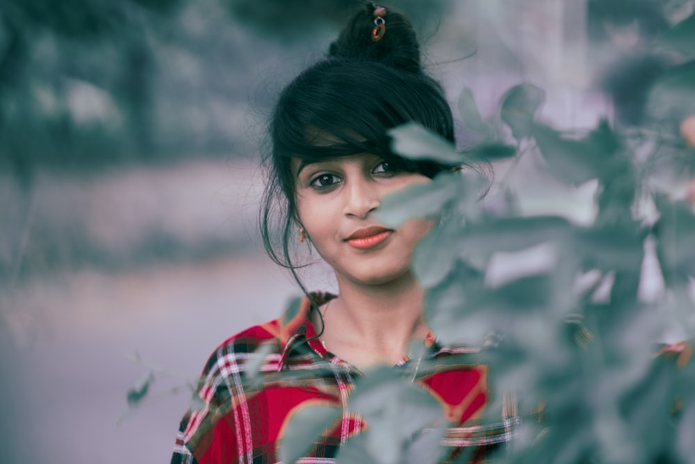 woman standing infront of green-leafed plant at daytime