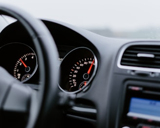 black vehicle dashboard with speedometer on 100