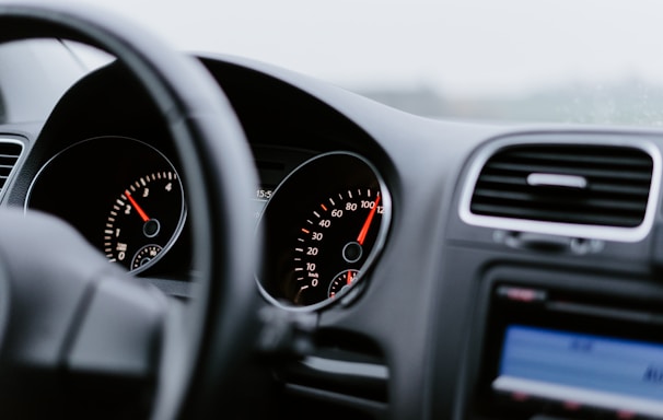 black vehicle dashboard with speedometer on 100