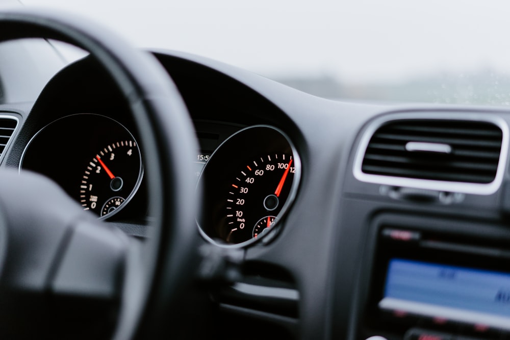 black vehicle dashboard with speedometer on 100