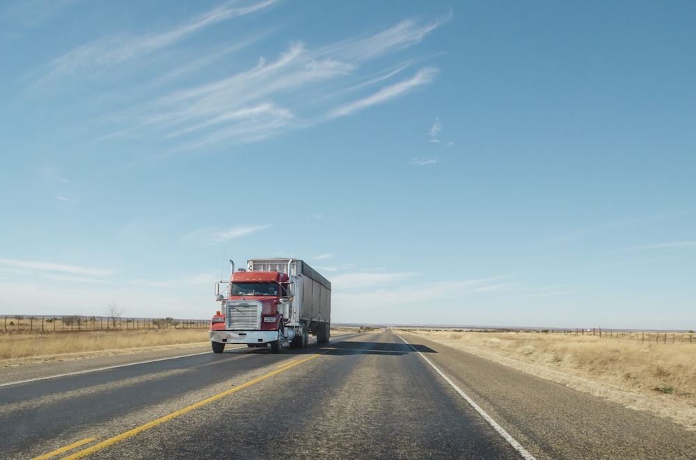 trailer truck passing on road during daytime