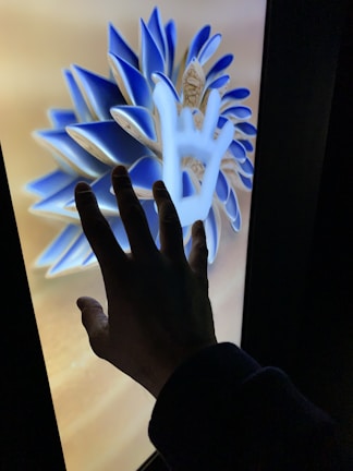 Close-up of hands uploading a vibrant digital artwork onto a sleek online dropbox interface.