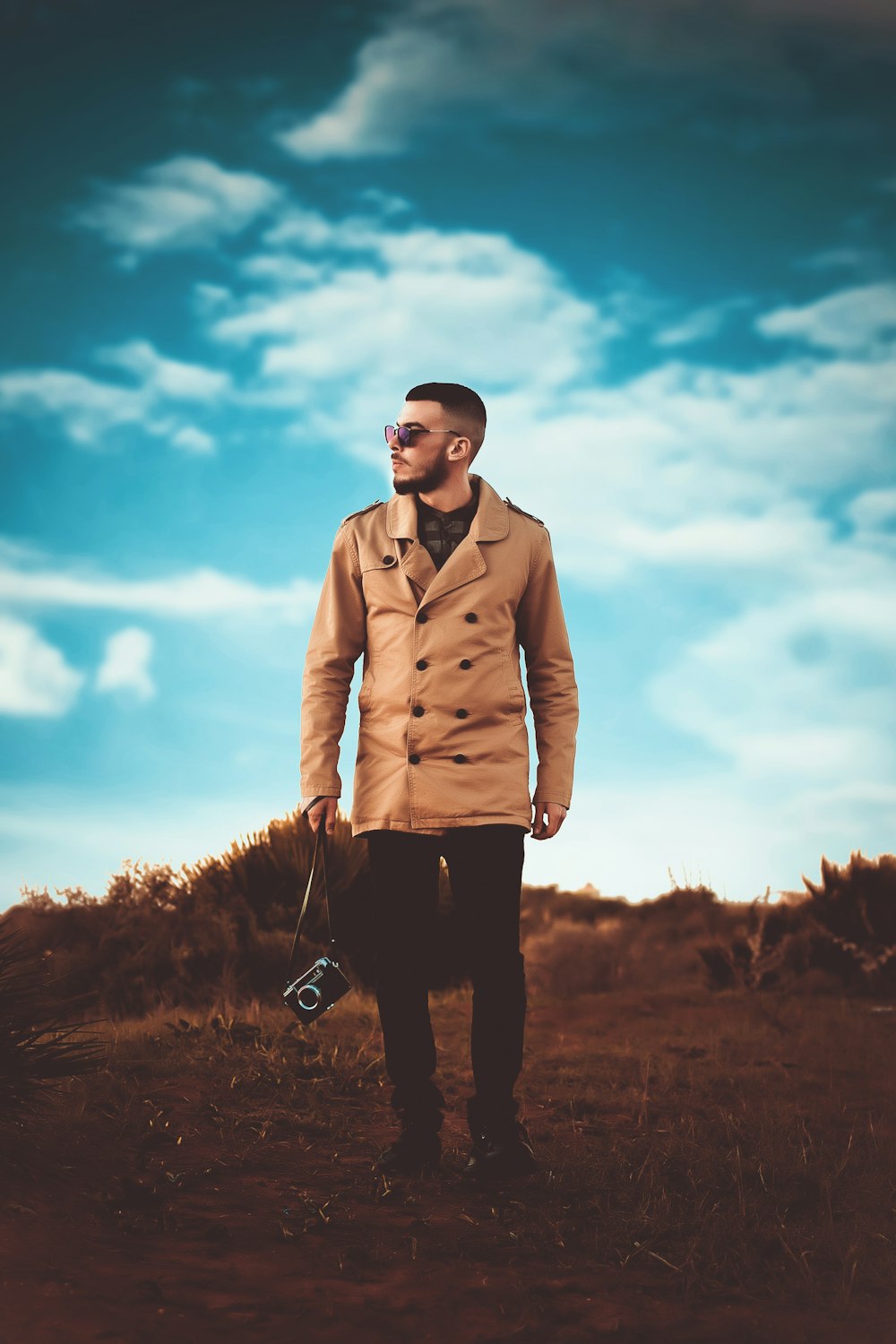 man wearing brown peacoat standing on the field