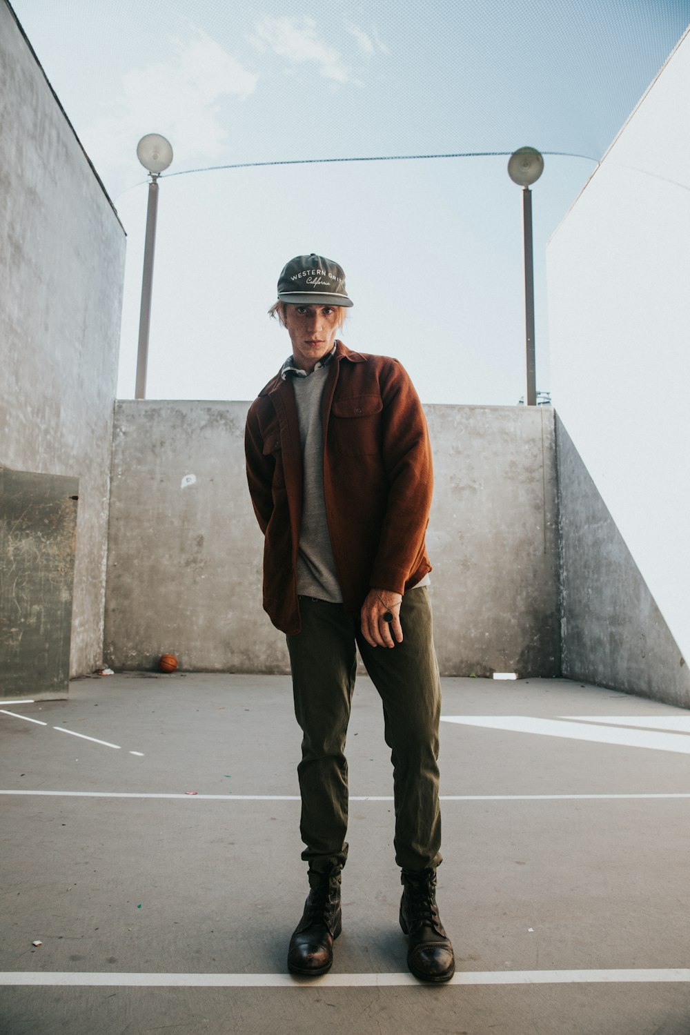 man wearing jacket standing near wall