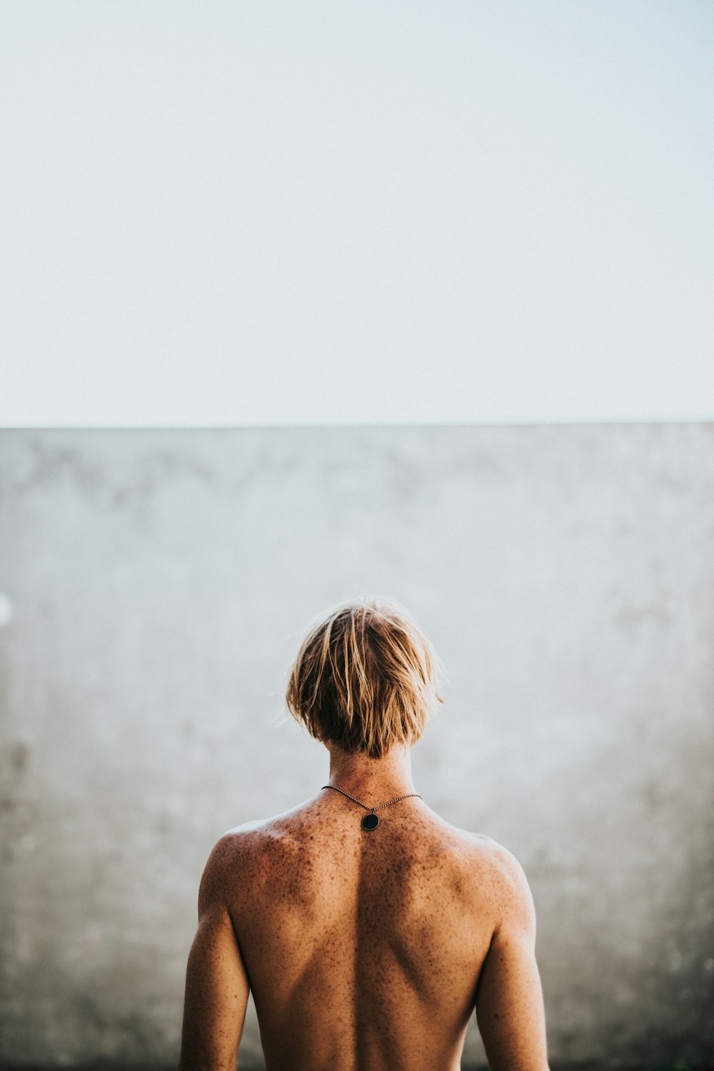 half naked man facing wall