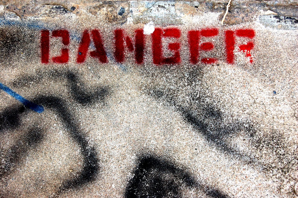 terreno in cemento con stampa di testo di pericolo rosso