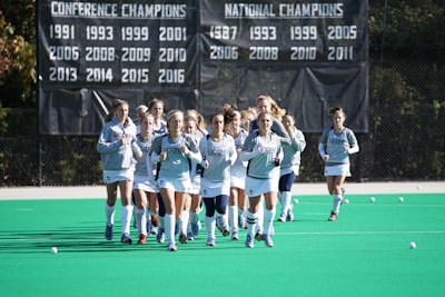 group of women athletes jogging on field field hockey google meet background