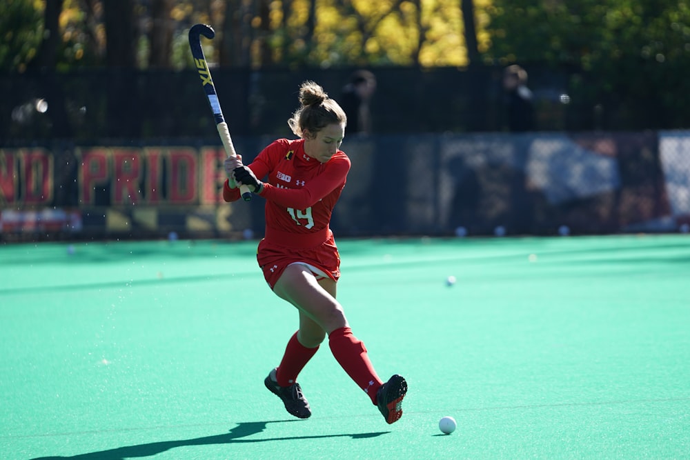 Frau spielt tagsüber Hockey auf Feldern