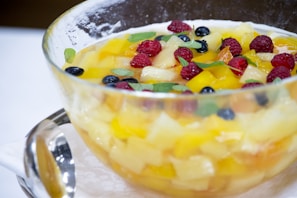Close-up of a colorful bowl of fresh fruit salad with berries and mint leaves