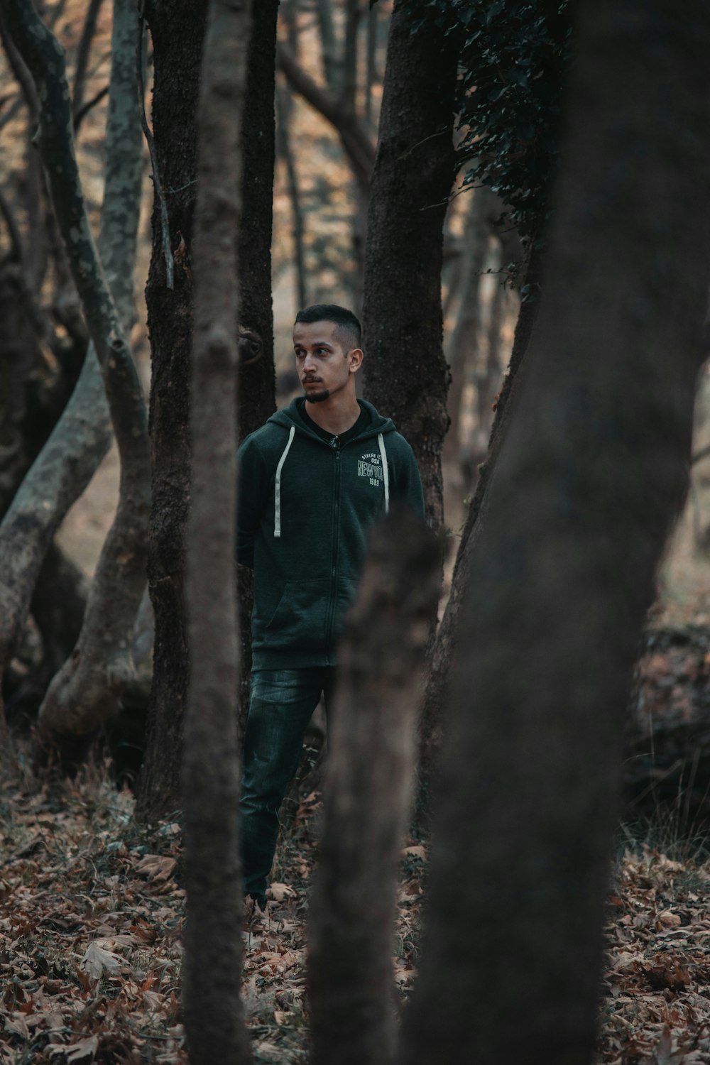 man in hoodie in forest