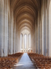 a large cathedral with rows of wooden chairs