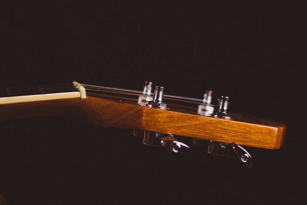 shallow focus photo of brown guitar headstock