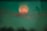 a blurry image of a person standing in front of a full moon