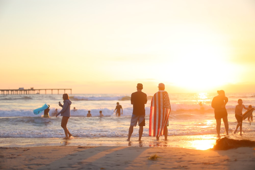 people on beach during golden hour