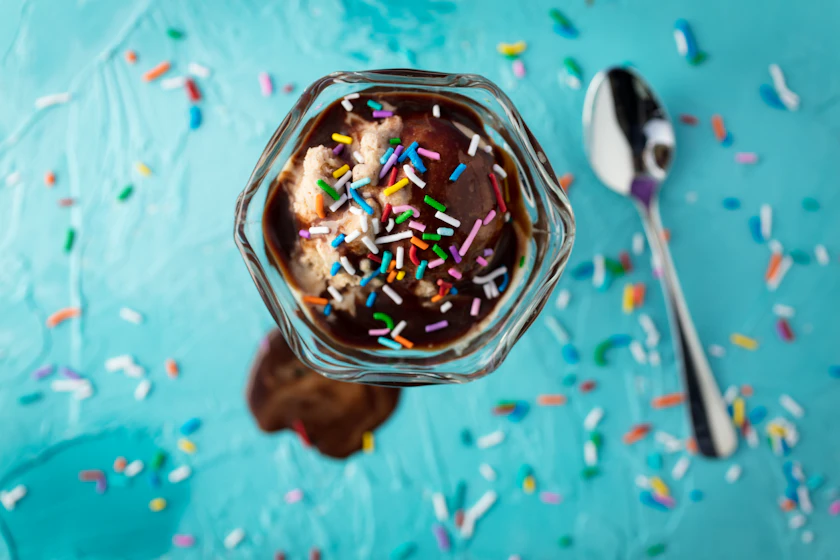 A loaded chocolate sundae with sprinkles and sauce