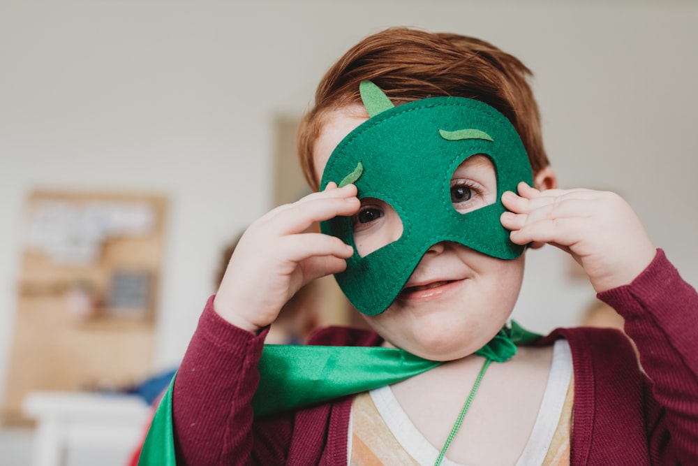 menino segurando máscara verde