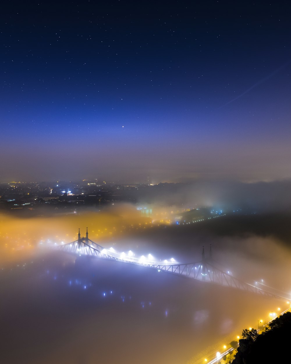 bridge covered with fog during nighttime