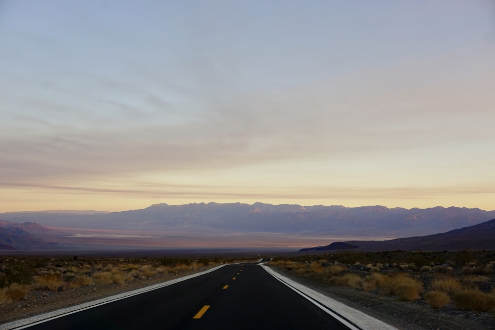 black road under cloudy sky