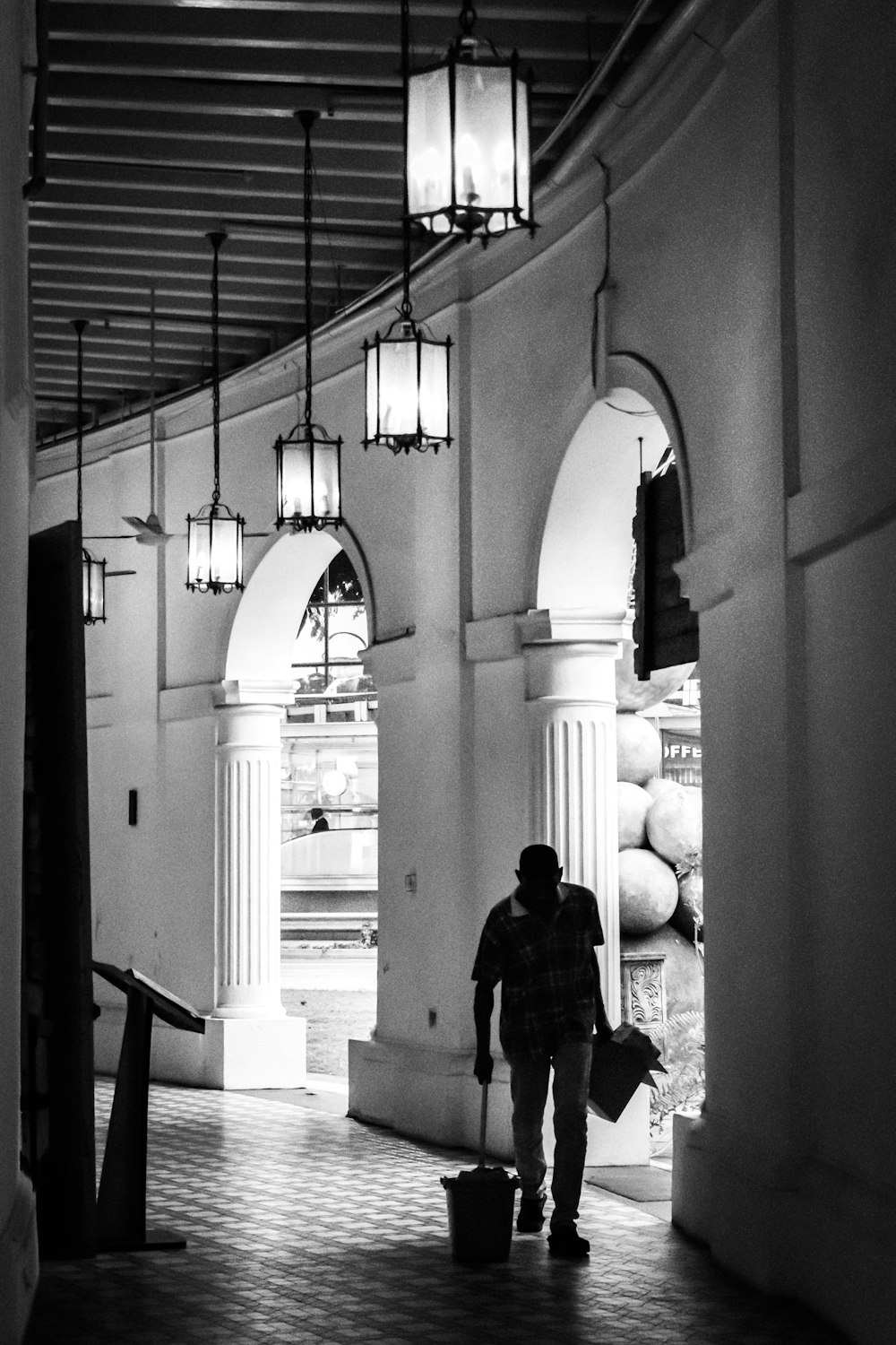 grayscale photography of man inside hallway